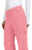 Pink pants with a textured fabric and a drawstring waistband, featuring side pockets and a branding logo.