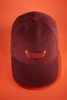 A maroon six-panel cap made of heavy cotton with a logo on the front.