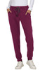 A person wearing burgundy jogger pants with a drawstring waist, paired with a white long-sleeve top and white sneakers.