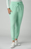 A pair of mint green jogger pants with a drawstring waist and side pockets, featuring a small logo.