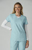 A scrubs top in light blue, featuring a V-neck and two front pockets, worn by a smiling model.
