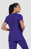 A purple women's top is worn by a model from a rear view, featuring short sleeves and a relaxed fit.