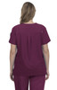 A back view of a woman wearing a burgundy scrub top. The top features a pleat detail and a logo on the sleeve.