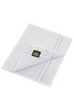 A white guest towel with a textured finish and a branding label in the corner.