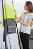 A woman arranges bath towels on a rack, featuring lime green, grey, and white towels. The image includes branding.