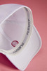 A white High Performance Flexfit® cap displaying its inner lining and structured brim, featuring a logo.