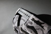 A grey camouflage cap with an adjustable strap at the back, featuring a logo.