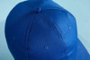 A blue 6-panel cap made of organic cotton, featuring a logo on the front.