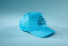 A light blue 5 panel cap made from organic cotton, featuring a logo on the front.