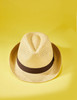 A straw hat in yellow with a brown band, positioned on a yellow background.
