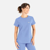 A light blue round neck top with a pocket, designed as part of scrubs uniforms, featuring a logo on it.
