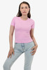 A pink fitted t-shirt displayed on a model, paired with light denim jeans. The shirt has a small logo.