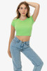 A model poses in a bright green cap sleeve baby rib crop top and light blue jeans. The top features a fitted design.