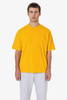 A yellow short sleeve pocket tee worn with grey pants, featuring a basic design and a logo.