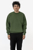 A green heavy fleece pullover is worn by a model standing in a neutral setting, with a logo visible on the garment.