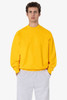 A yellow heavy fleece pullover displayed on a model, paired with grey trousers. The pullover features a logo.