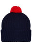 A knitted beanie in navy blue with a red pompon on top, featuring a ribbed design.