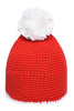 A red knitted hat with a white pompon on top and a contrast white stripe at the bottom. It features a logo.