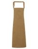 A tan Chino Cotton Bib Apron featuring a pocket and two side pockets, with an adjustable neck strap and a logo.