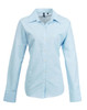A light blue women's button-up Oxford shirt with long sleeves and a collar, featuring a logo.