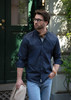 A slim fit men's button-up shirt in navy, paired with light jeans and a beige jacket, featuring a logo.
