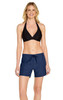 A model wearing navy women's cargo board shorts with a black bikini top. The shorts feature a drawstring waist and have branding.