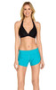 A model stands wearing turquoise swim shorts paired with a black bikini top. The product has a logo visible.