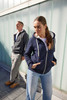 A navy doubleface jacket featuring a hood and pockets, worn by a woman standing beside a man in a grey jacket.