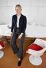 A navy ladies zip-cardigan displayed on a model, paired with grey trousers, in a modern office setting.