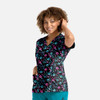 A floral print women's V-neck top featuring a black background with pink and blue flowers, and two pockets.