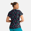 A women's V-neck top featuring a vibrant floral print in pink, blue, and green on a black background, with a logo.
