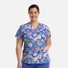 A women's V-neck top featuring a vibrant coral and ocean-themed print on a blue background, with a logo on the chest.