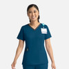 A teal women's double V-neck top with short sleeves, featuring a logo and a pocket.