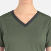 A green women's top featuring a contrast double V-neck design and shoulder buttons, with a logo.