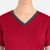 A red women's top featuring a double V-neck design with a contrasting grey trim and a logo on the neckline.