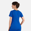 A woman wearing a blue contrast double V-neck top, seen from the back, with a subtle grey detail at the neckline.