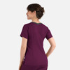A womens top in dark purple with a double V-neck and contrasting grey detailing at the back. It features a logo.