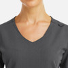 A close-up of a women's grey V-neck top featuring metallic detail and a stylish neckline.