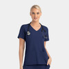 A women’s mock wrap top in navy blue with contrast panels and a stethoscope around the neck.