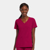 A mock wrap top in a rich fuchsia colour featuring short sleeves and front pockets. It has a logo on it.