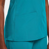 A teal women's mock wrap top featuring two front pockets and a sleek design. It includes a logo on the fabric.