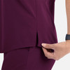 A close-up of a women's tuckable v-neck top in a rich plum colour, featuring side slits for comfort.
