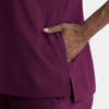 A close-up of a women's top in deep purple, featuring a notched neck and a side pocket.