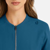 A women's bomber jacket in teal with a full zip and a logo on the shoulder.