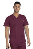 A man wears a maroon men's tuckable V-neck top with a chest pocket and holds a pair of scissors.