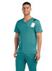 A men's teal v-neck top featuring three pockets, with a tag attached, modelled by a smiling man.