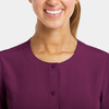 A round neck snap jacket in purple, featuring buttons at the front and a close-up of the neckline.