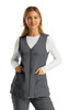 A grey women's V-neck vest with a zip front and pockets, worn over a white long-sleeve top.