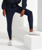 Fitted joggers in navy blue with a drawstring waist. A stylish and comfortable fit. White sneakers complement the look.