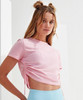 A pink ruched crop top with short sleeves, featuring adjustable side ties, worn by a model.